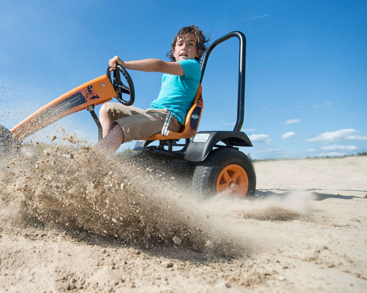 Kind rijdt op een BERG go-cart in het zand
